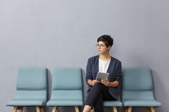cute-businesswoman-looks-pensively-aside-waits-meeting-with-partners